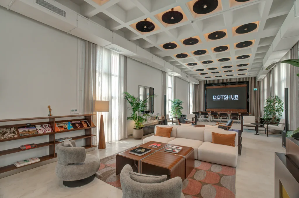 DotsHub'ın kanepeli lounge alanı ve toplantı ekranı