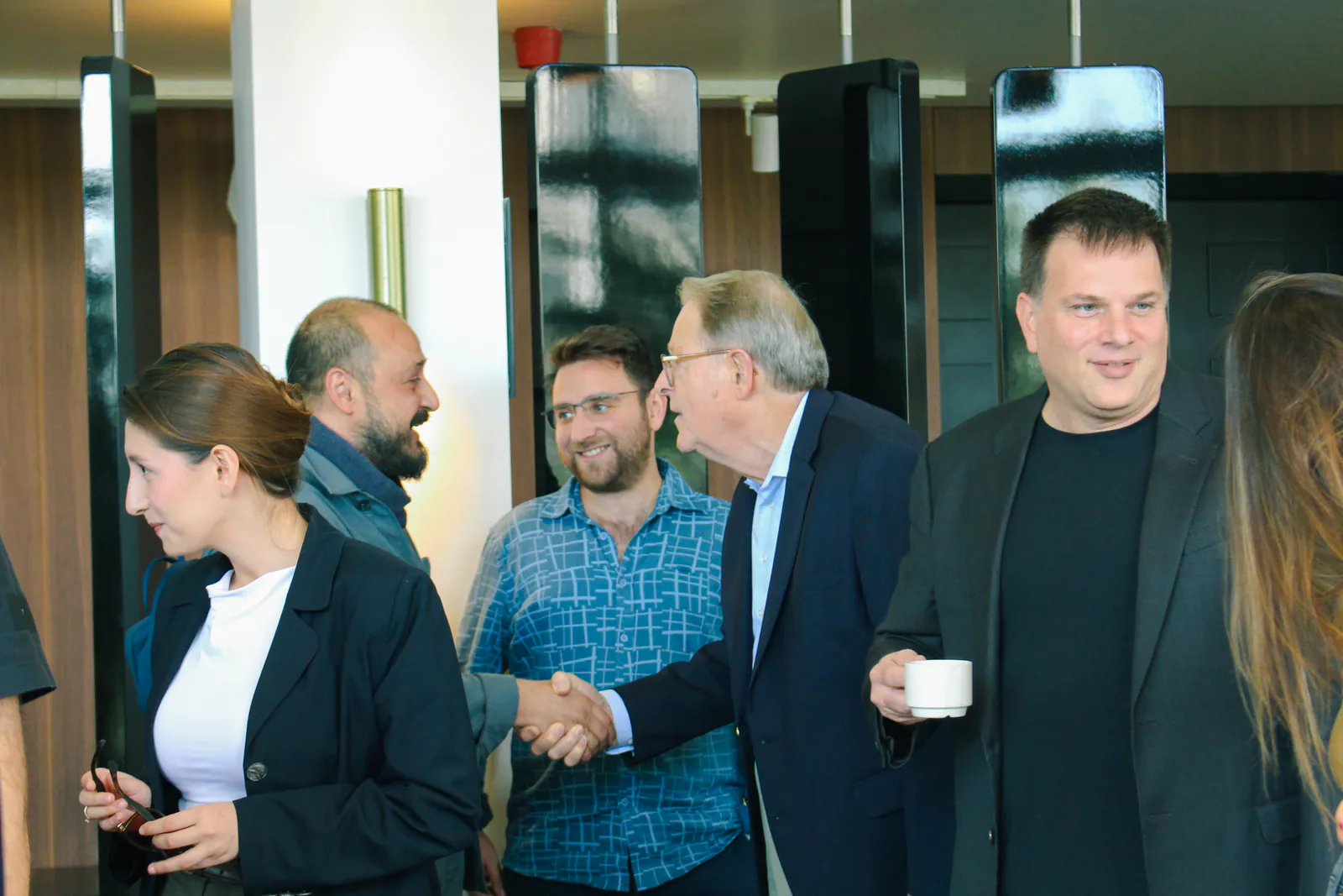 DotsHub'da bir networking buluşmasında tokalaşan katılımcılar