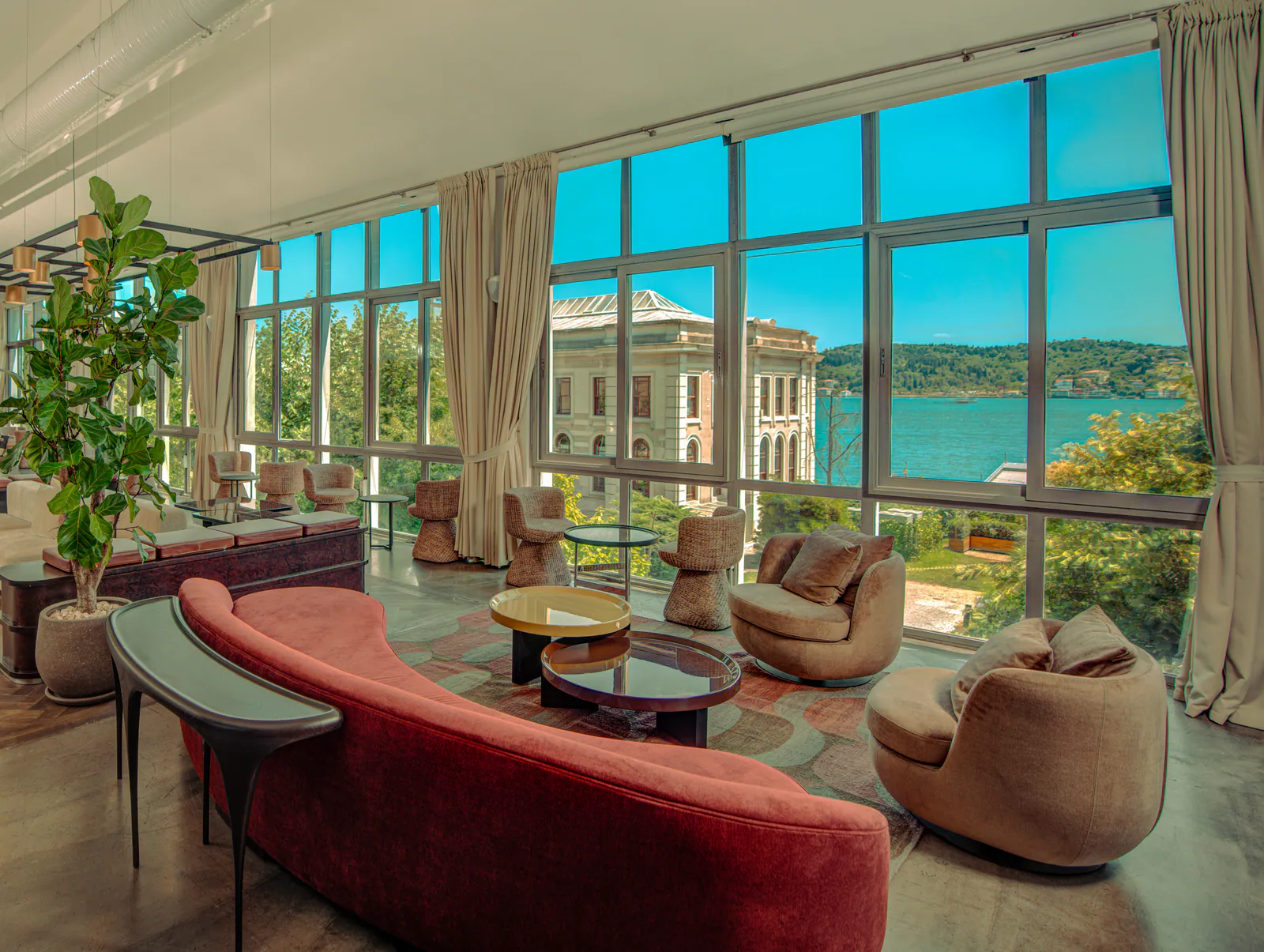 Boğaz manzaralı lounge'da kırmızı kanepe ve koltuklar